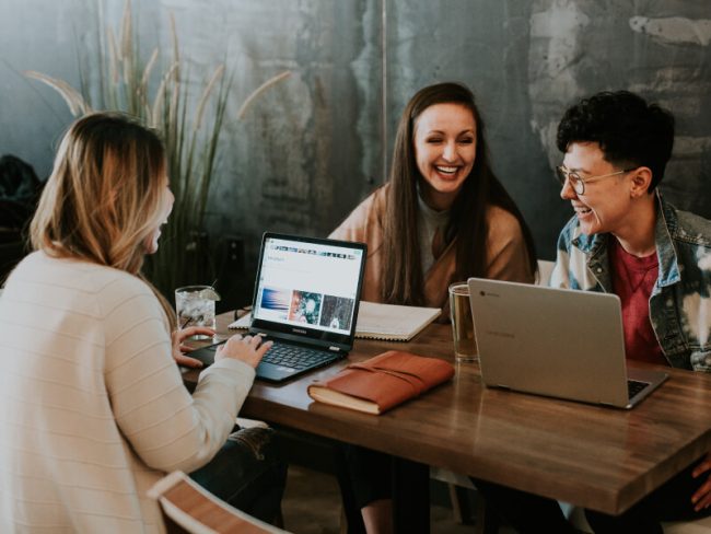 People sitting in front of computers talking about small business accounting
