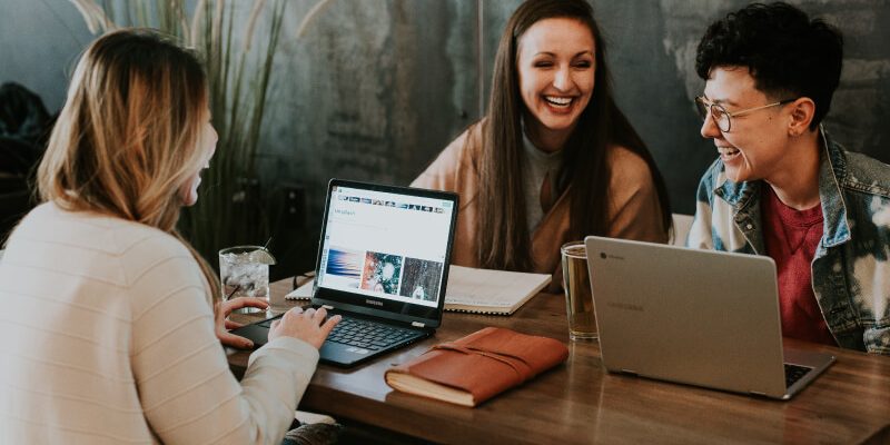 People sitting in front of computers talking about small business accounting